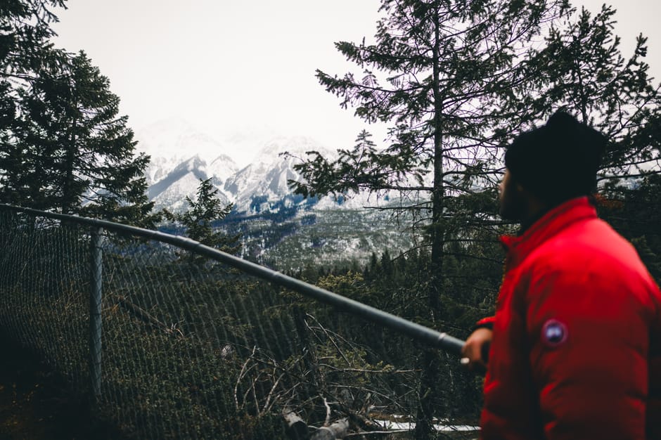 A hiker in a red jacket admires the Canadian Rockies