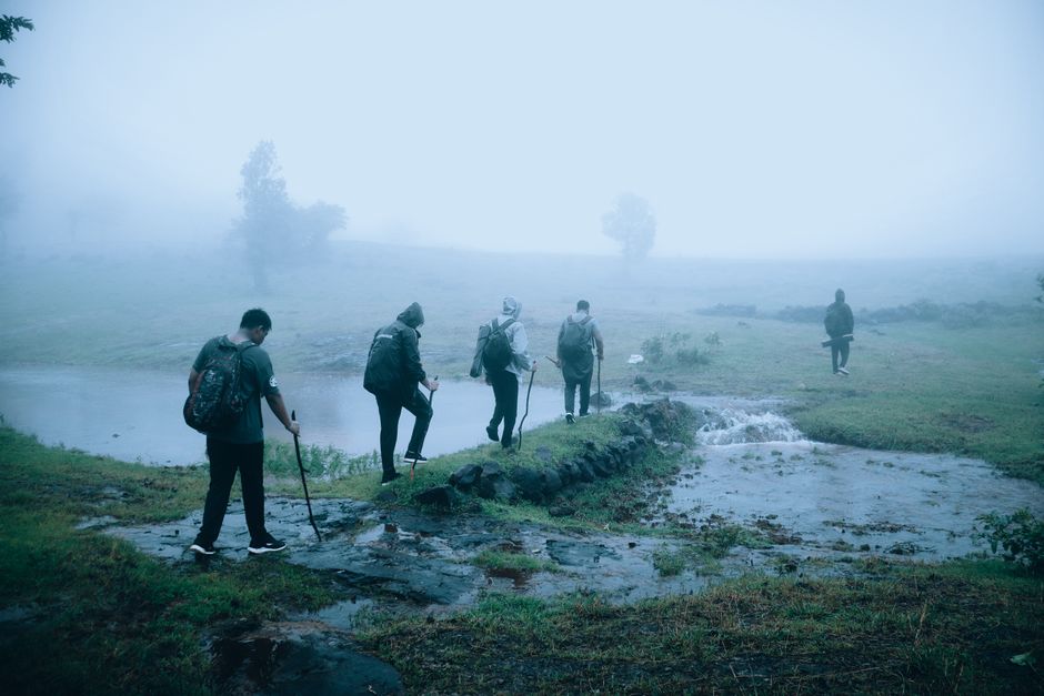 A group of hikers trekking through foggy countryside