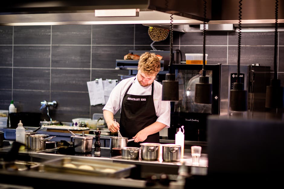 Chef preparing meal in a modern kitchen with various cookware