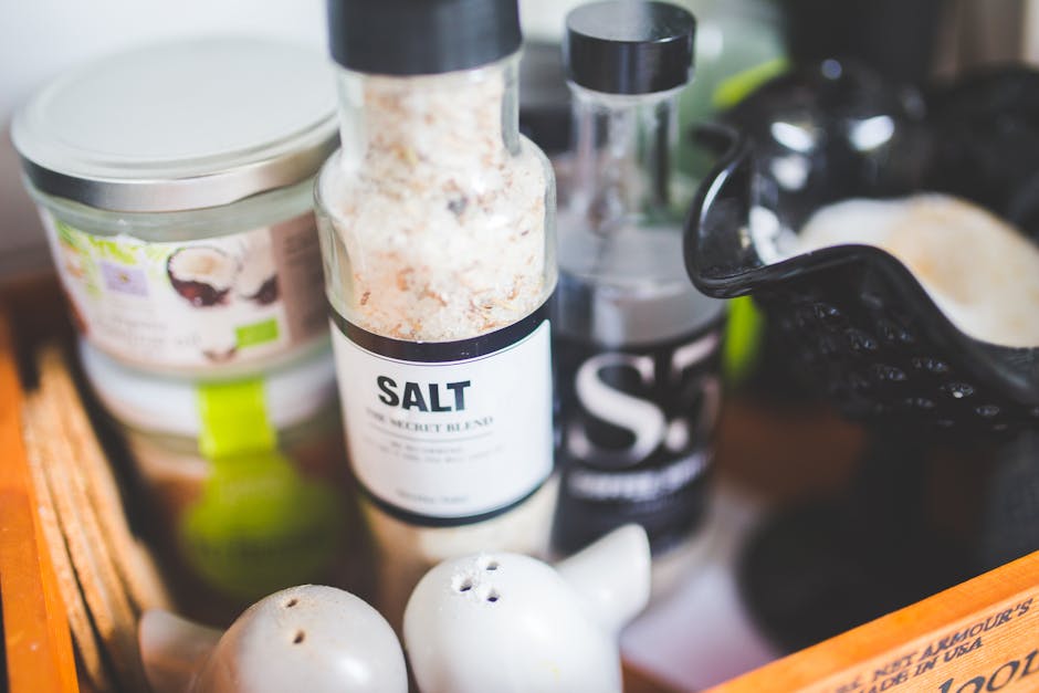 Close-up view of various kitchen condiments, featuring salt shaker and other containers