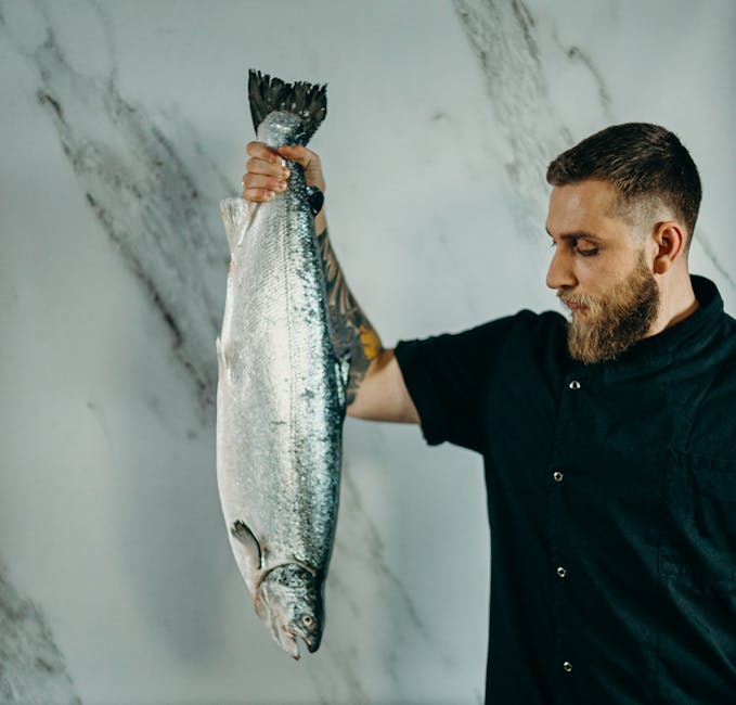 A chef holding a fresh salmon fish in a kitchen, ready for preparation