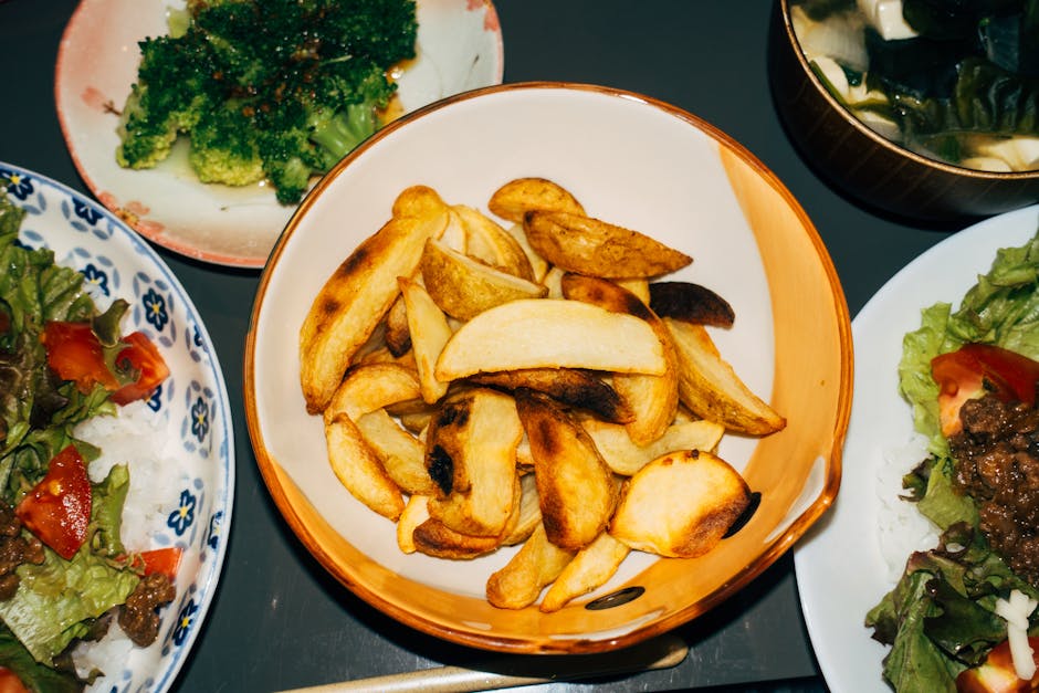 Delicious meal featuring crispy potato wedges, fresh salads, and vibrant broccoli sides